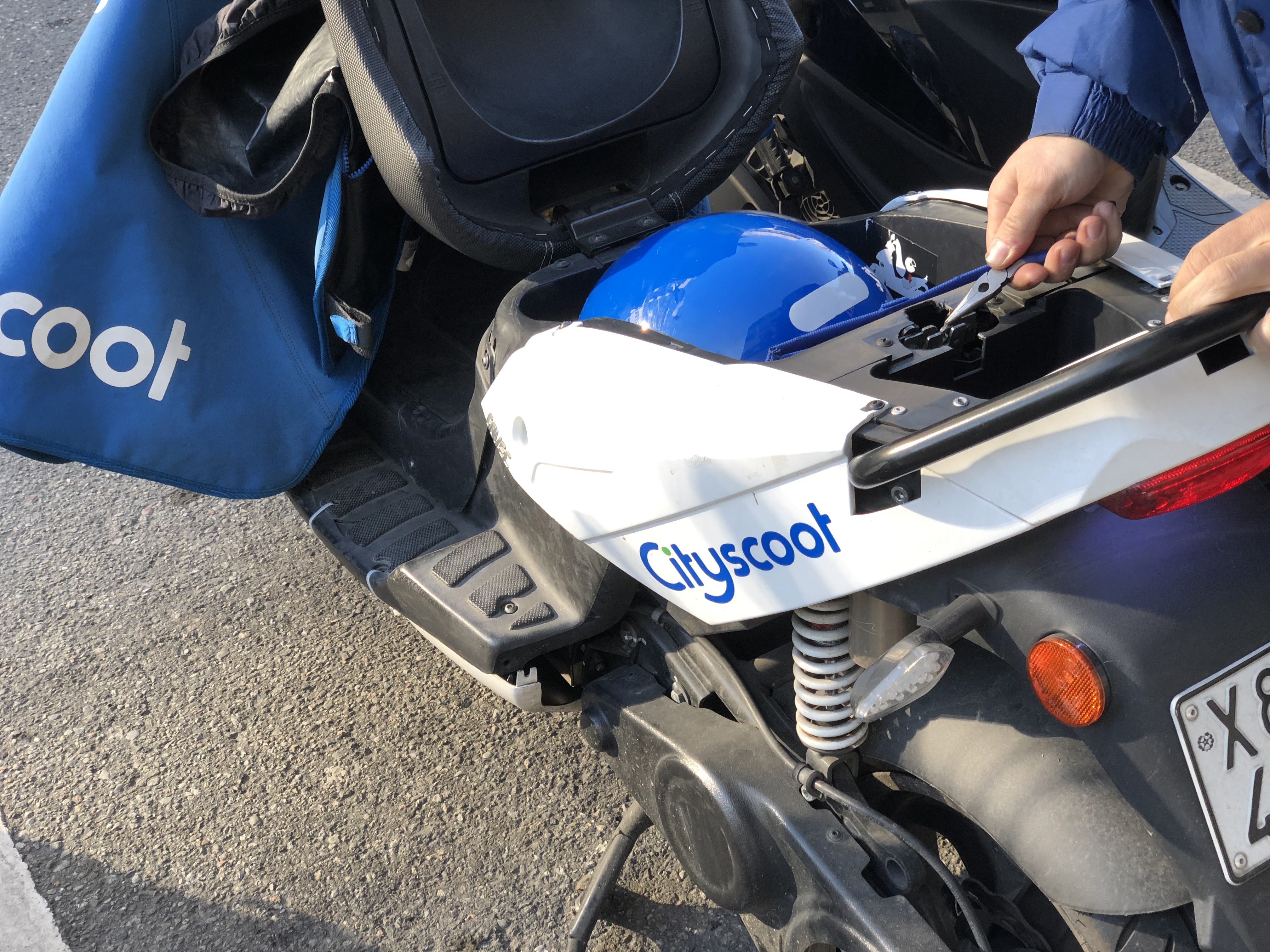 Agent Cityscoot réparant un scooter